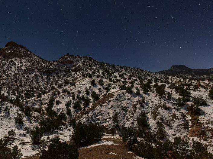 Night photo of snow and stars and Cerro Pedernal