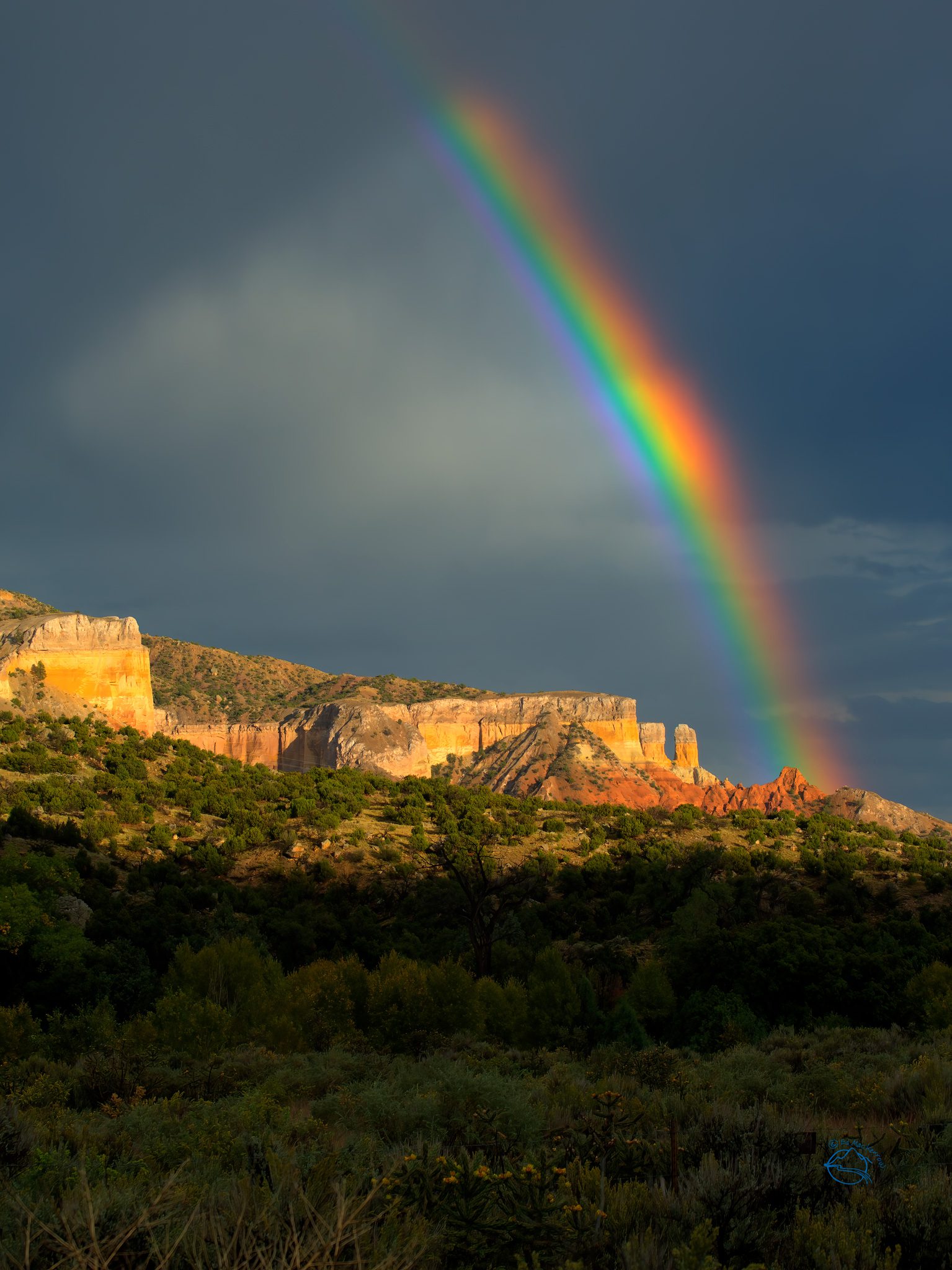 Photo of a rainbow over rock formations in New Mexico.